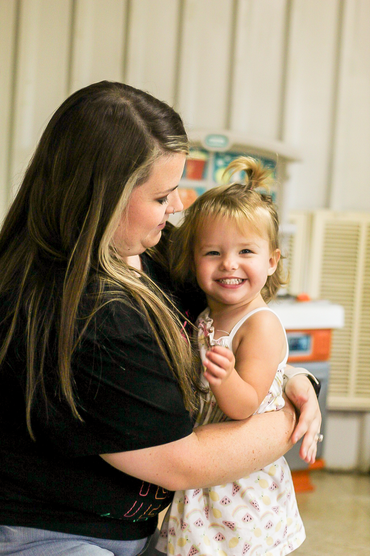 Toddler laughing with teacher